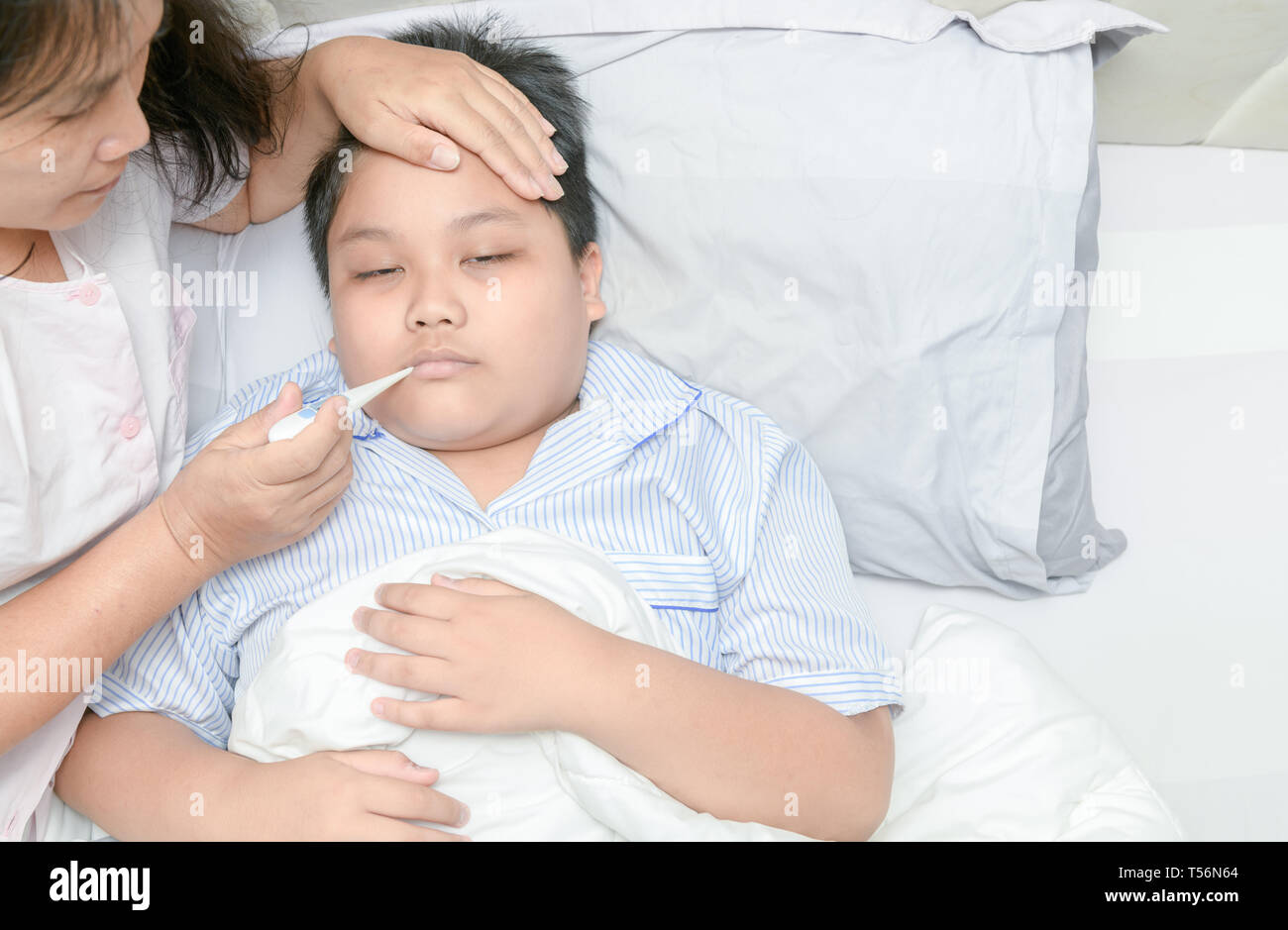Mother measuring temperature of ill kid. Sick child with high fever