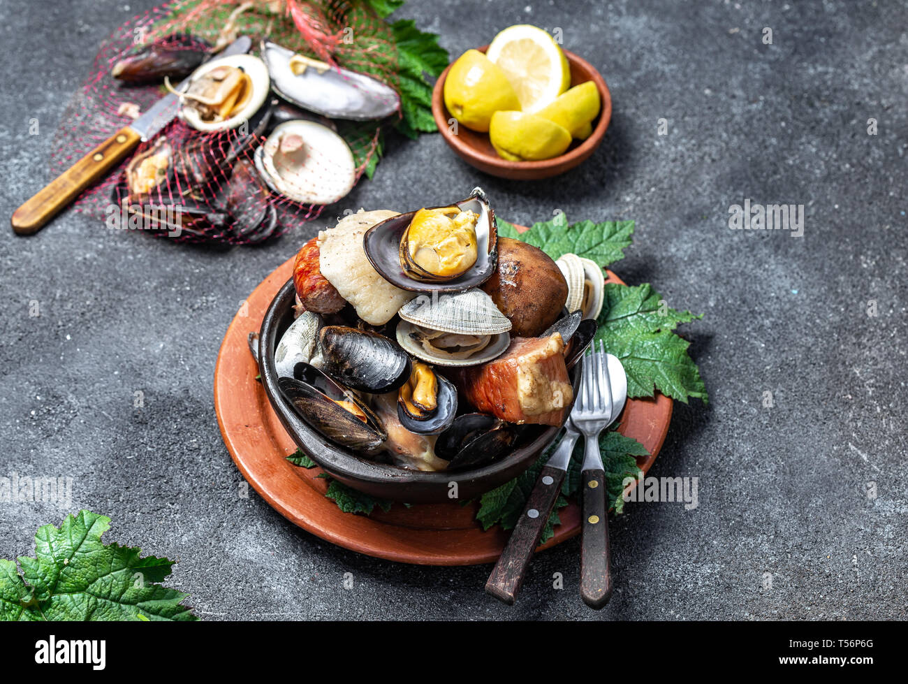 Famous traditional dish of the south of Chile and the Chiloe archipelago - Curanto al Hoyo, Kuranto. Different seafood, meat and potatoes milcao Stock Photo