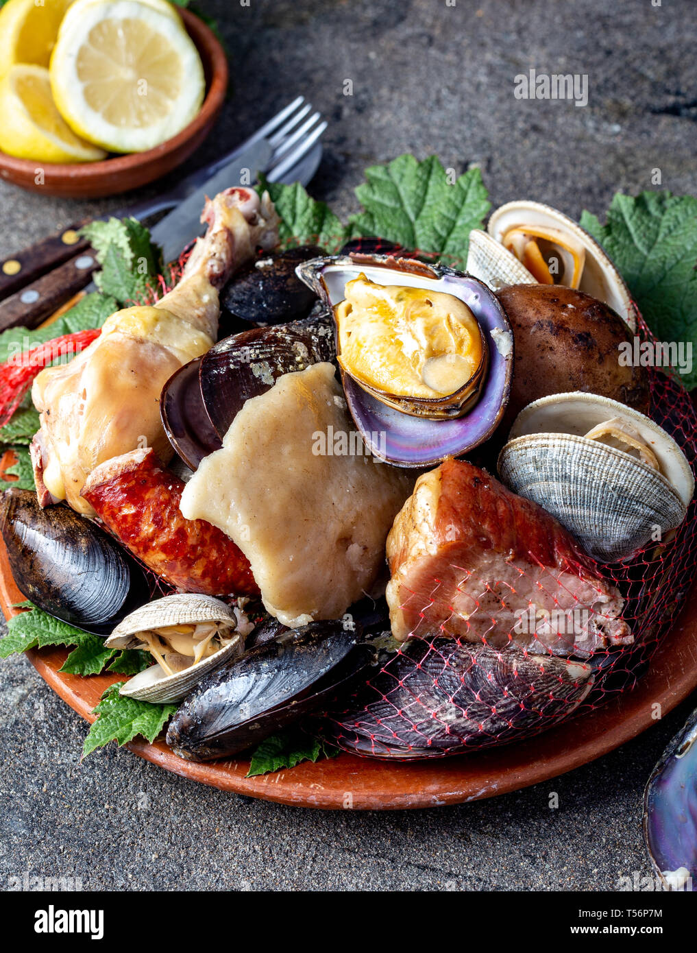 Famous traditional dish of the south of Chile and the Chiloe archipelago - Curanto al Hoyo, Kuranto. Different seafood, meat and potatoes milcao Stock Photo