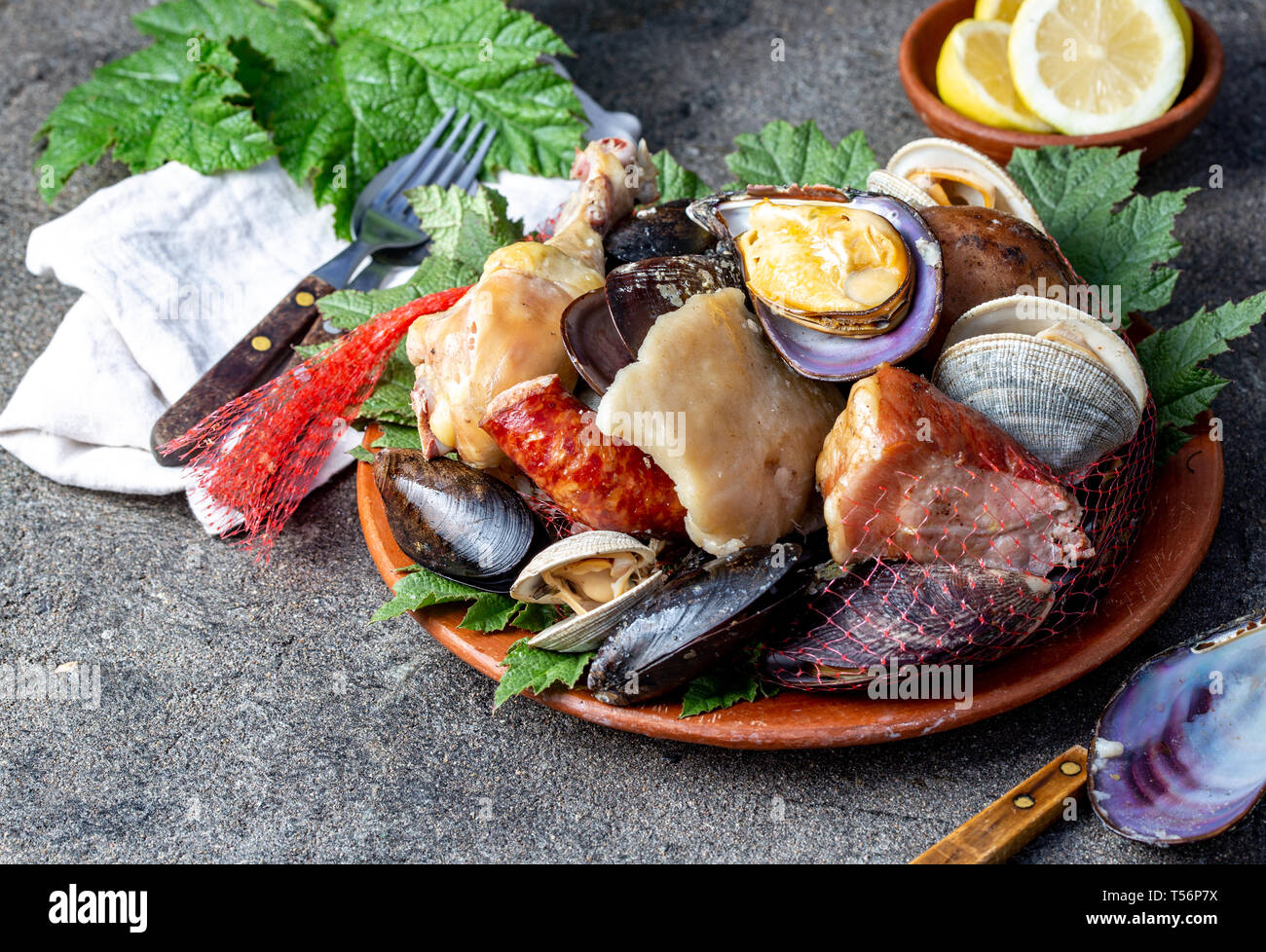 Famous traditional dish of the south of Chile and the Chiloe archipelago - Curanto al Hoyo, Kuranto. Different seafood, meat and potatoes milcao Stock Photo