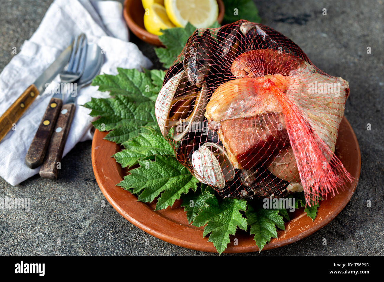 Famous traditional dish of the south of Chile and the Chiloe archipelago - Curanto al Hoyo, Kuranto. Different seafood, meat and potatoes milcao Stock Photo