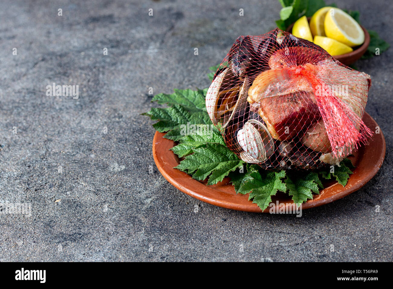 Famous traditional dish of the south of Chile and the Chiloe archipelago - Curanto al Hoyo, Kuranto. Different seafood, meat and potatoes milcao Stock Photo