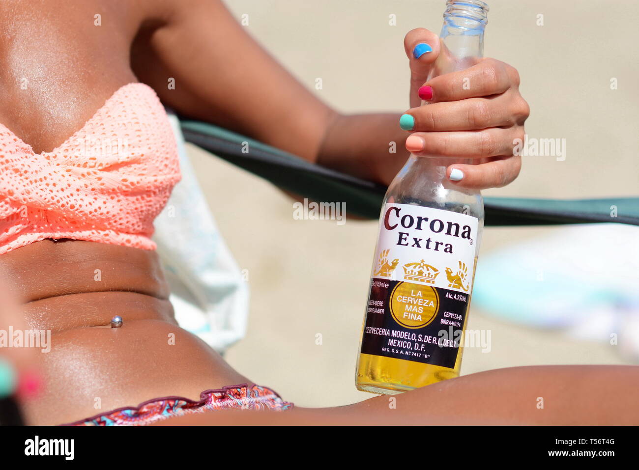 beautiful-blonde-sexy-girl-in-swim-wear-drinking-corona-beer-on-the-beach-T56T4G.jpg