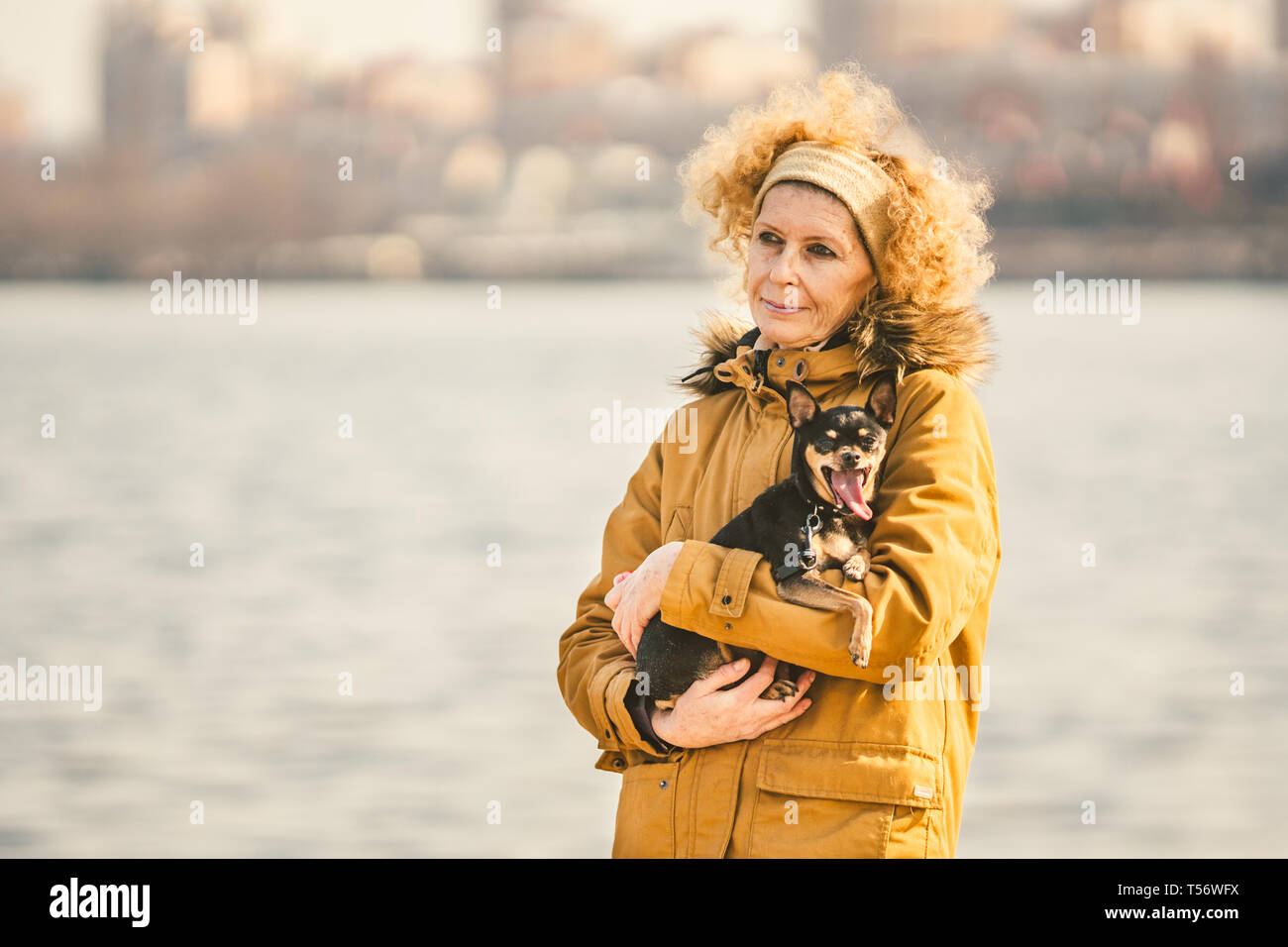 Portrait Of An Adult Blonde Curly Hair Caucasian Woman Holding A