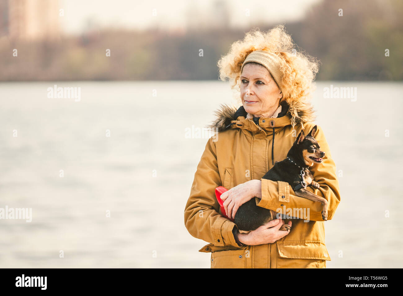 Portrait Of An Adult Blonde Curly Hair Caucasian Woman Holding A