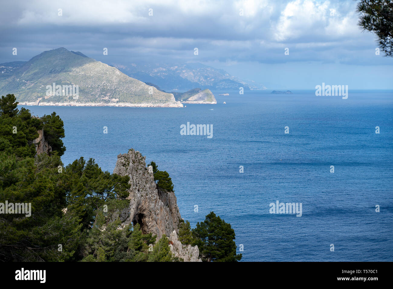 Capri, Pizzolungo, in primo piano l'Arco Naturale, sullo sfondo la penisola sorrentina. Visibili punta campanella, Nerano, i galli Stock Photo