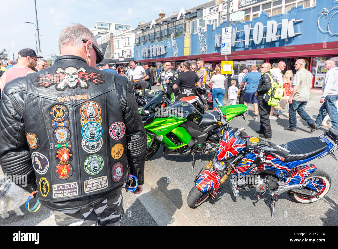 The 'Southend Shakedown' was for many years a regular Easter Bank Holiday Monday gathering at the seafront location attracting many thousands of motorcycles for their first big ride-out of the year - hence 'shakedown'. Official events ended a number of years previously due to costs although unofficial gatherings had continued, sometimes despite council attempts to stop them. A new volunteer team have taken the helm for 2019 hoping to kick start a new era - Southend Shakedown Resurrection. Male in black leather jacket with badges looks down on small Honda MSX bike in union flag colours Stock Photo