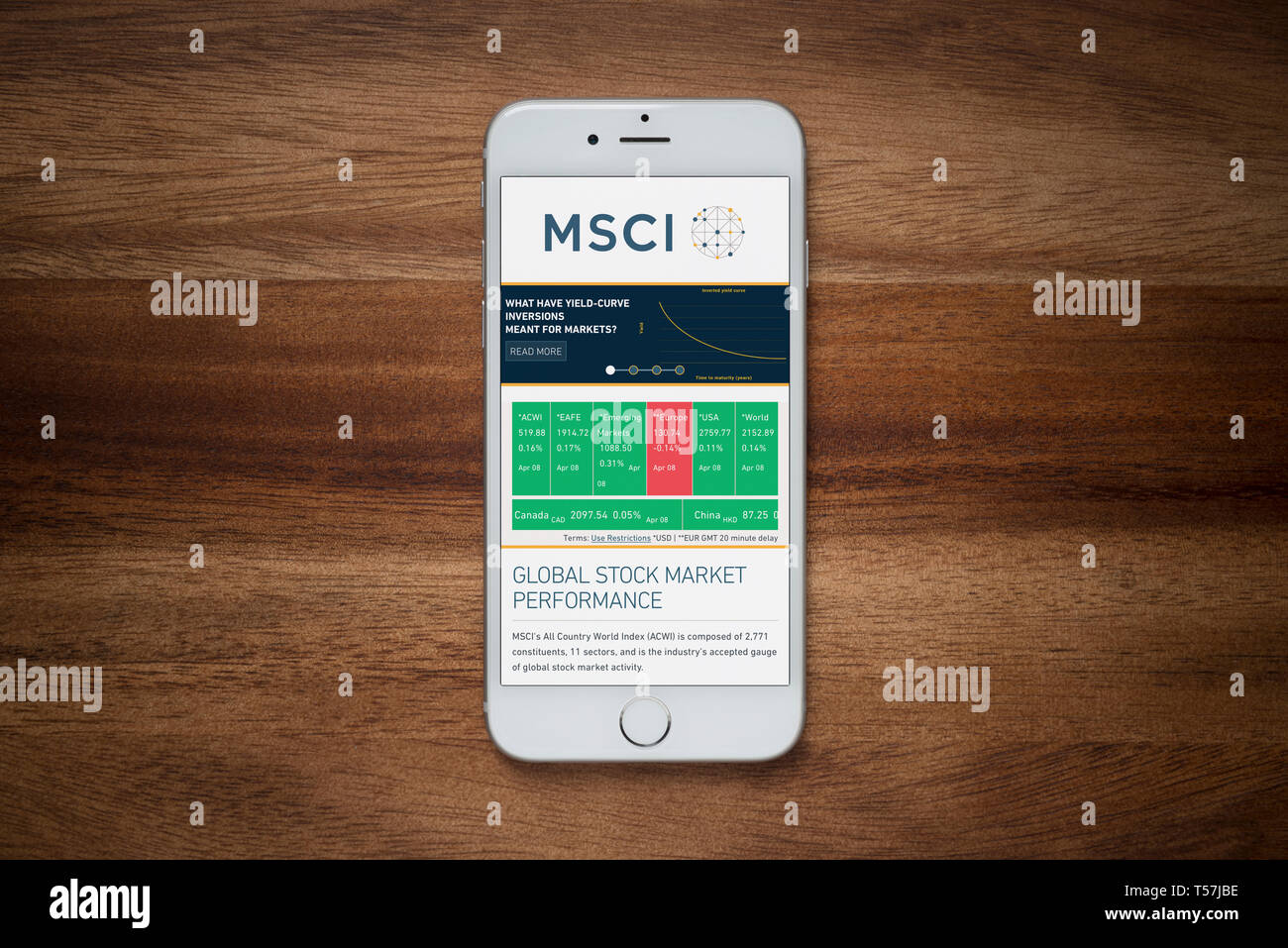 An iPhone showing the MSCI website rests on a plain wooden table (Editorial use only). Stock Photo