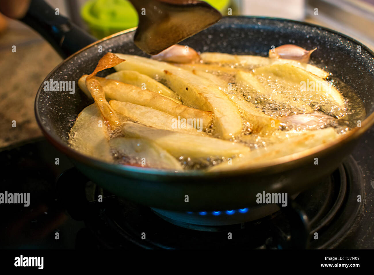 https://c8.alamy.com/comp/T57N09/frying-fries-and-garlic-in-oil-boiling-beautifully-on-old-cast-iron-pan-cooking-fry-potatoes-in-pan-in-spain2019-T57N09.jpg