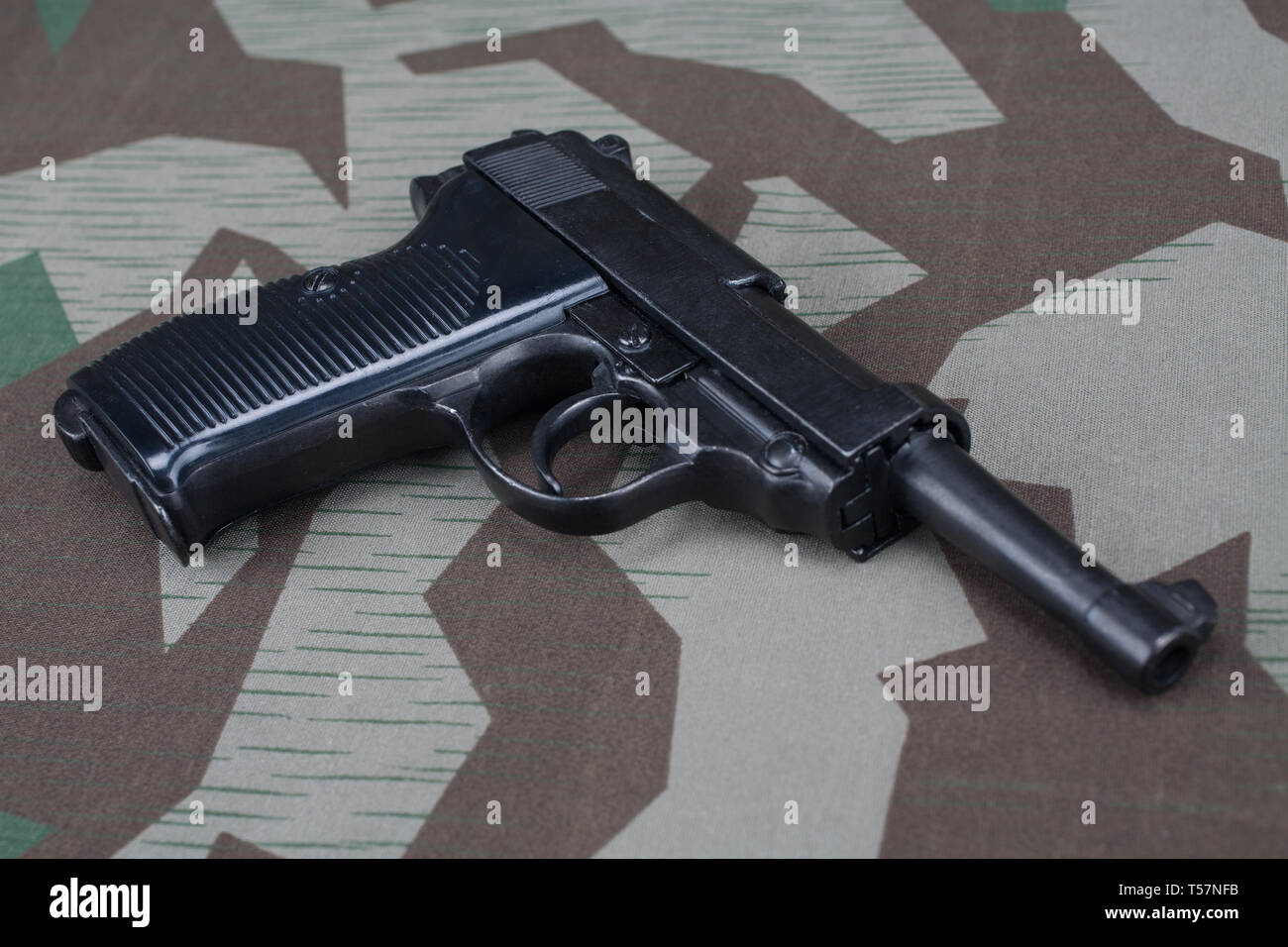 WWII era nazi german army 9 mm semi-automatic pistol on camouflaged uniform background Stock Photo