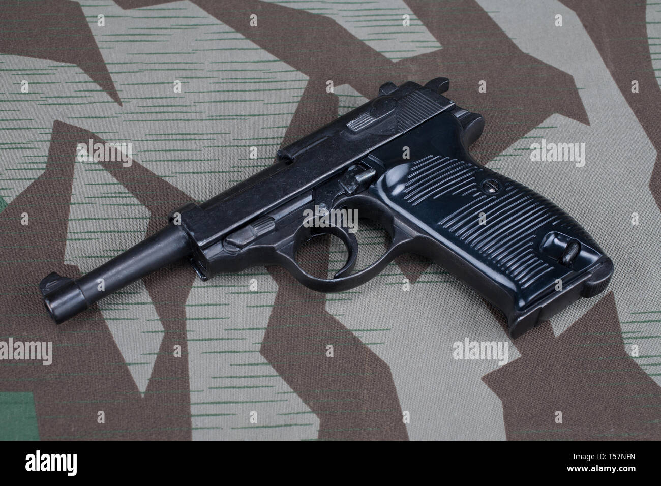 WWII era nazi german army 9 mm semi-automatic pistol on camouflaged uniform background Stock Photo