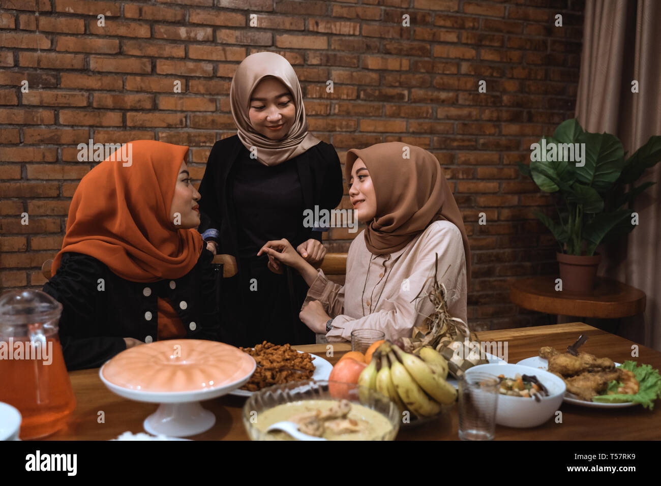 muslim woman talk to each other while dinner Stock Photo