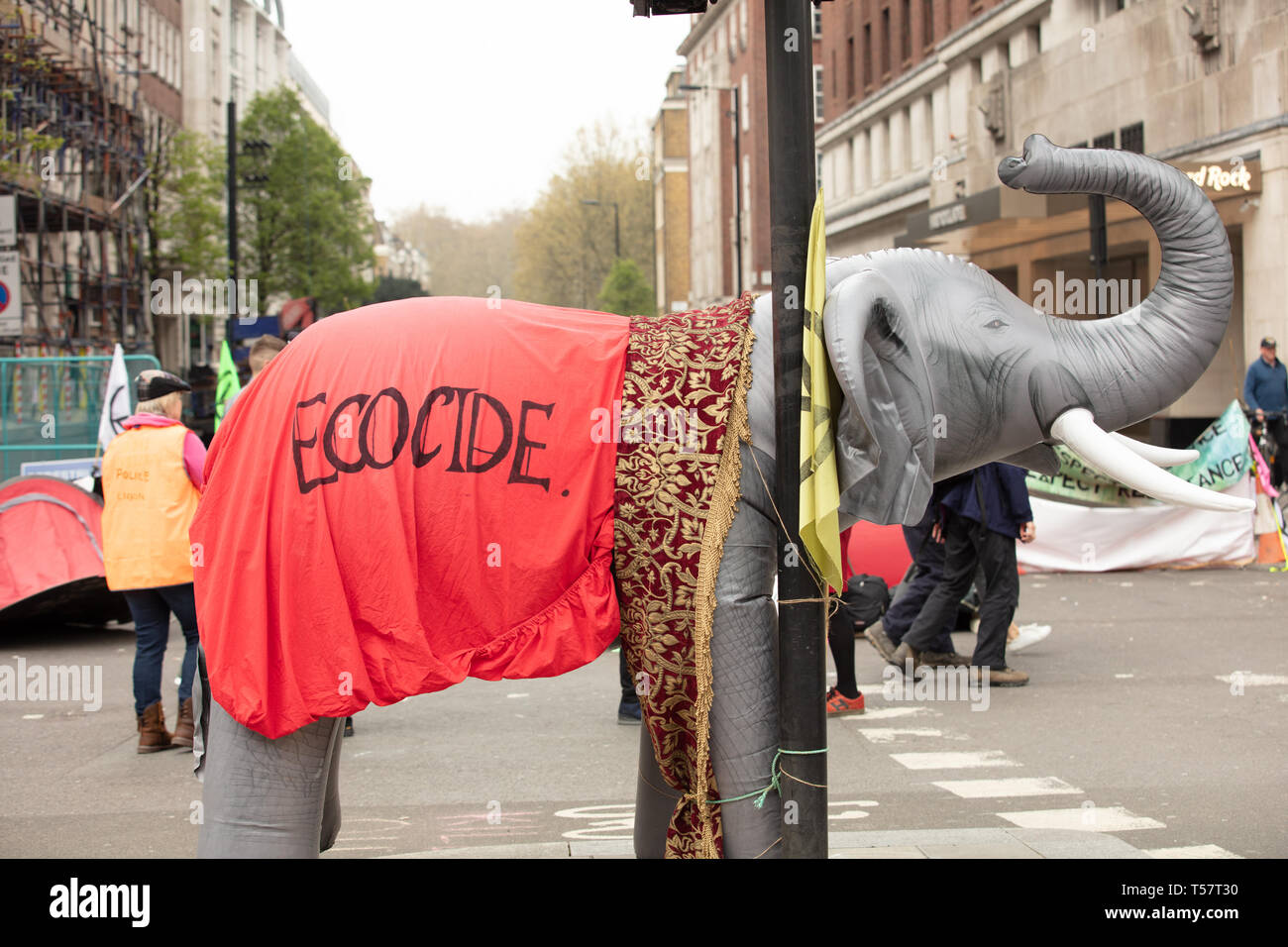 An elephant figure used during an Extinction Rebellion demonstration  seen draped with a red cloth with the word ecocide written on it. Stock Photo