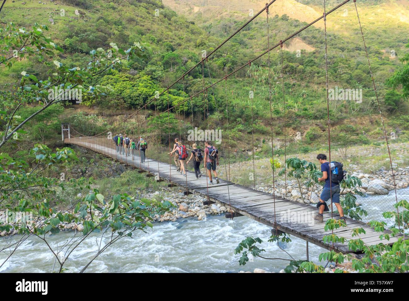 tourists crossing a hanging bridge in peru Stock Photo