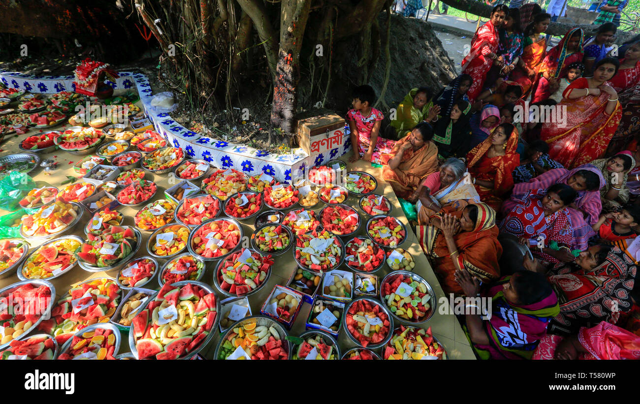 Devotees sit beside arrays of offerings placed under the ancient banyan tree, which is worshipped by local Hindus on the first day of Bengali Year. Na Stock Photo