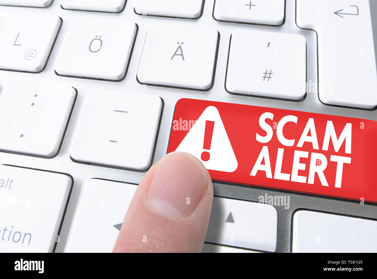 close-up of finger pressing red key labeled SCAM ALERT on computer keyboard Stock Photo