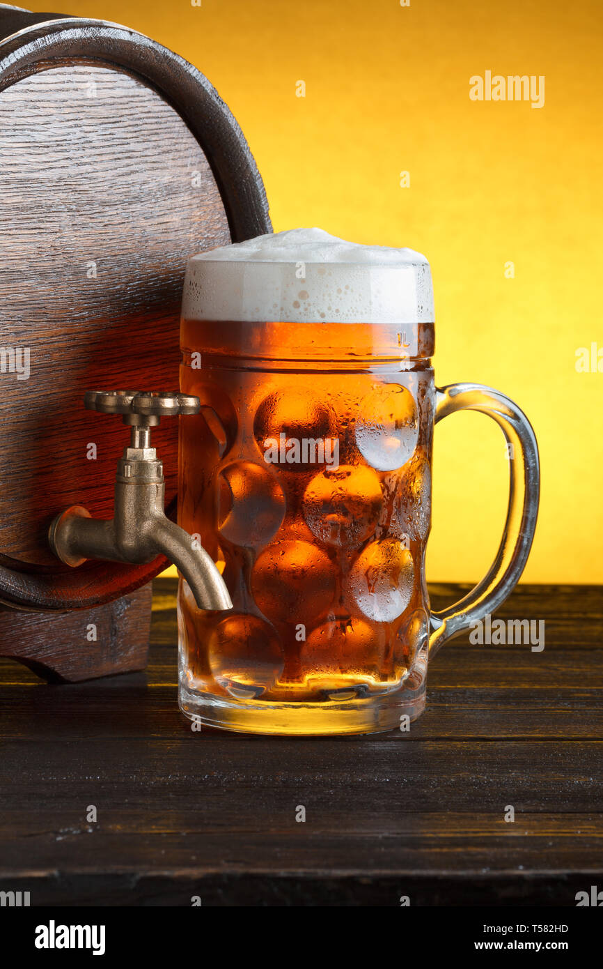 Vintage beer barrel with huge beer glass on wooden table still life close  up Stock Photo - Alamy