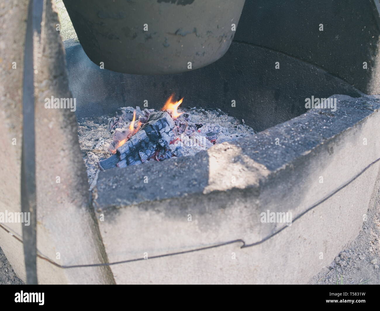 Concrete Cauldron Fireplace Outdoor with Small Fire Closeup Stock Photo