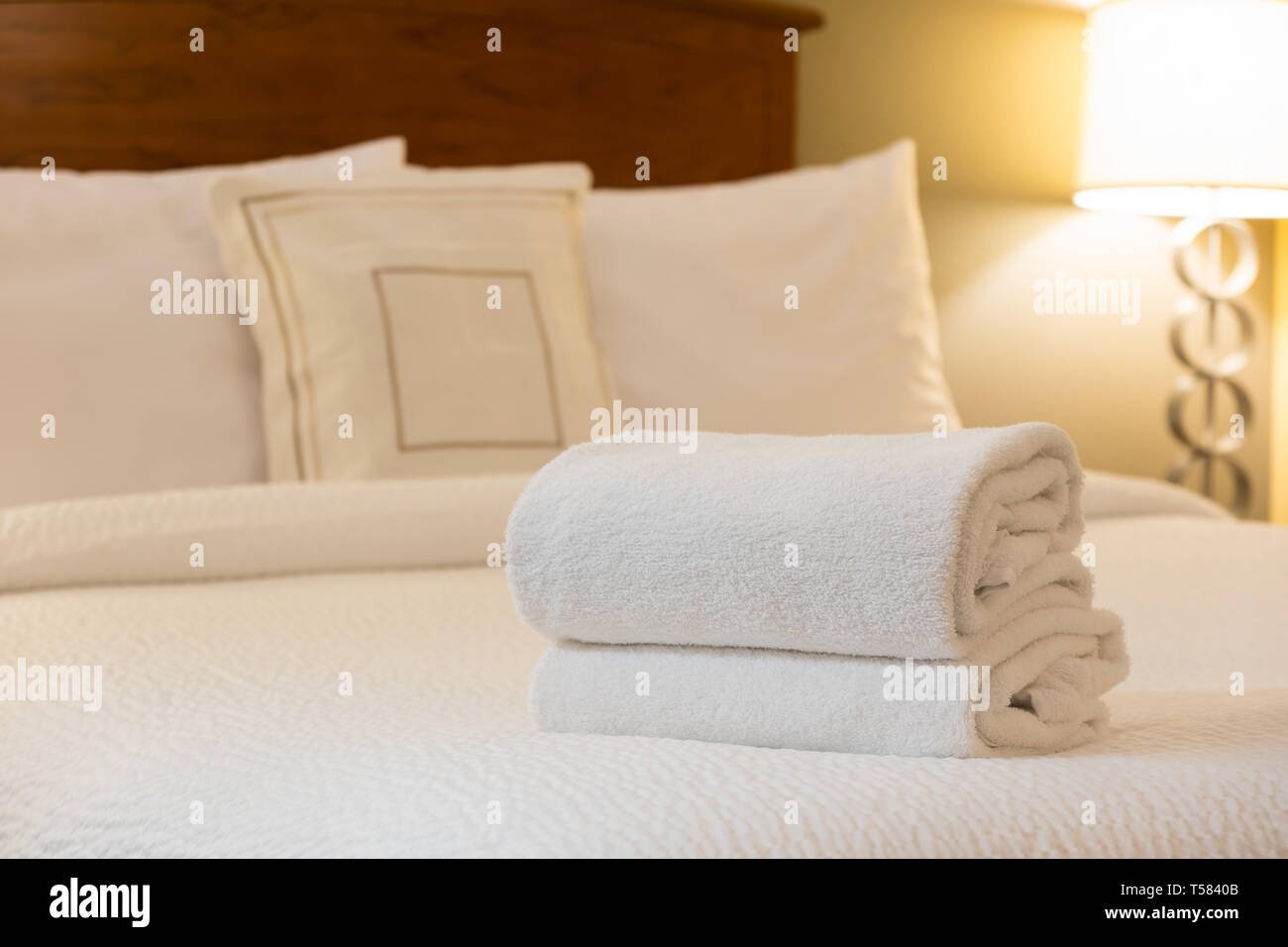White towel on bed in hotel room Stock Photo Alamy