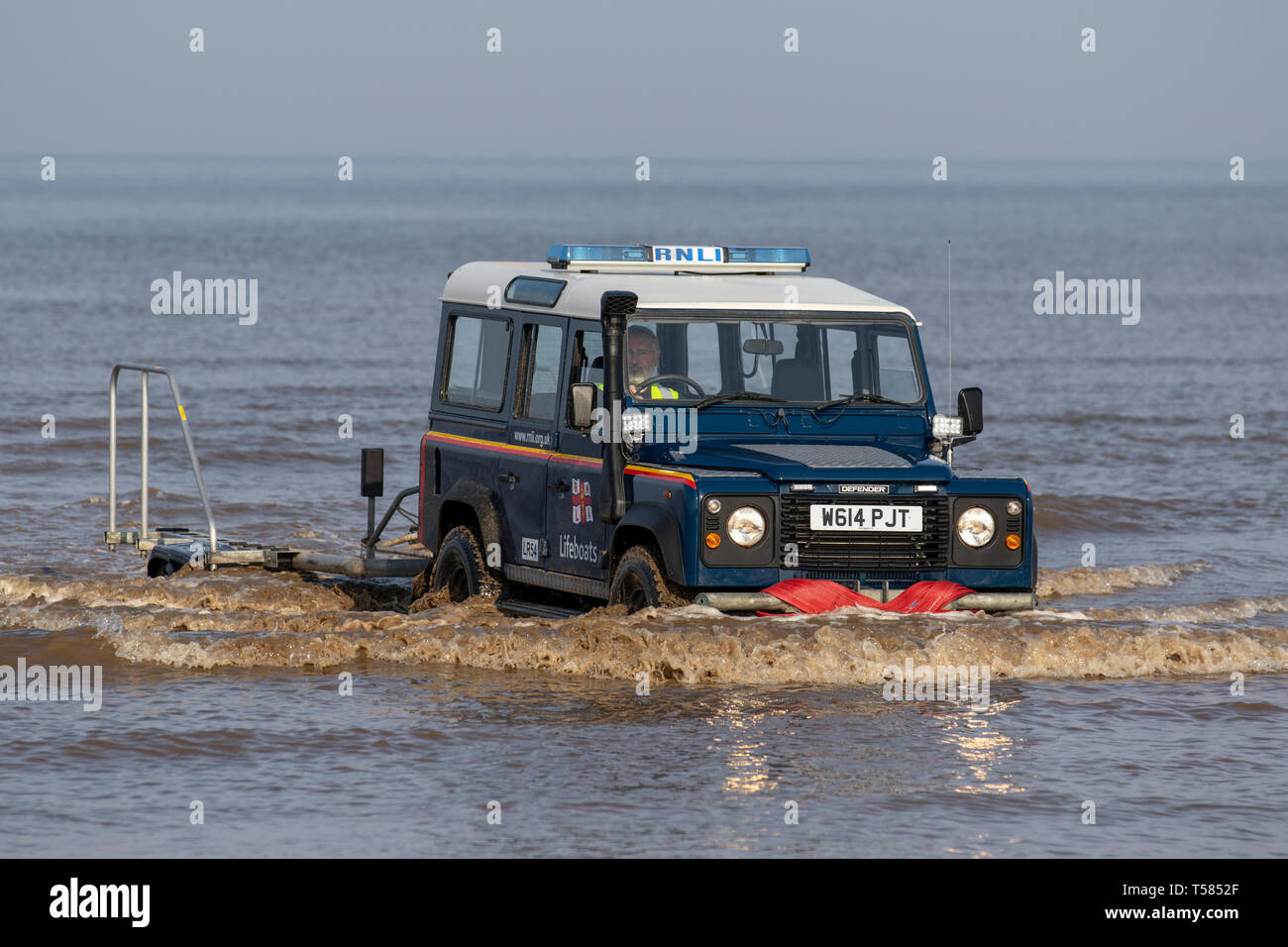 LifeGuard off-road beach & trail patrol rescue vehicle H M Coastguards land rover, with snorkel exhaust, Lifeguards and lifeboat crew join forces in  lifesaving training exercises in the sea at Blackpool, UK Stock Photo