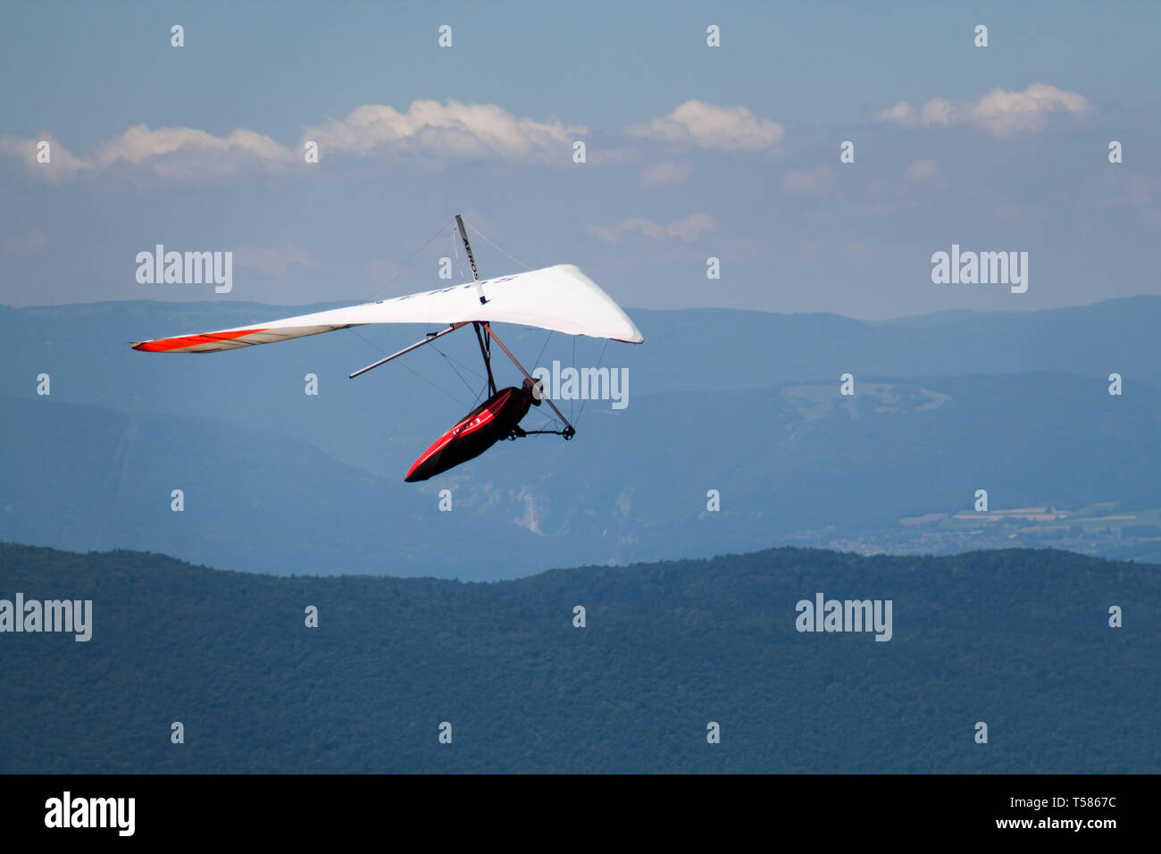 Man Hand-gliding over Mointains on a Hot Summer Day Stock Photo