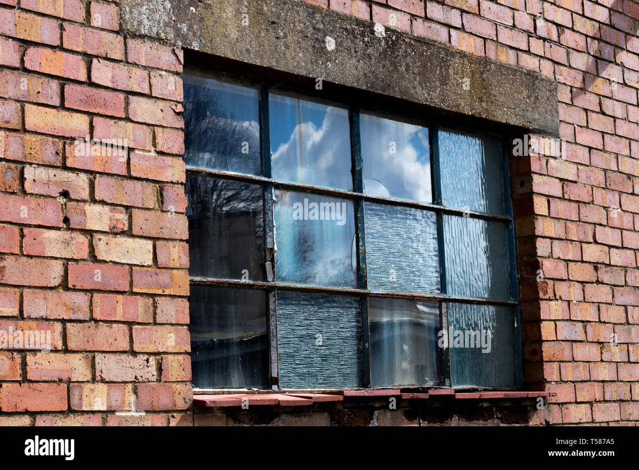 Dilapidated metal casement window frame on condemned derelict factory ...