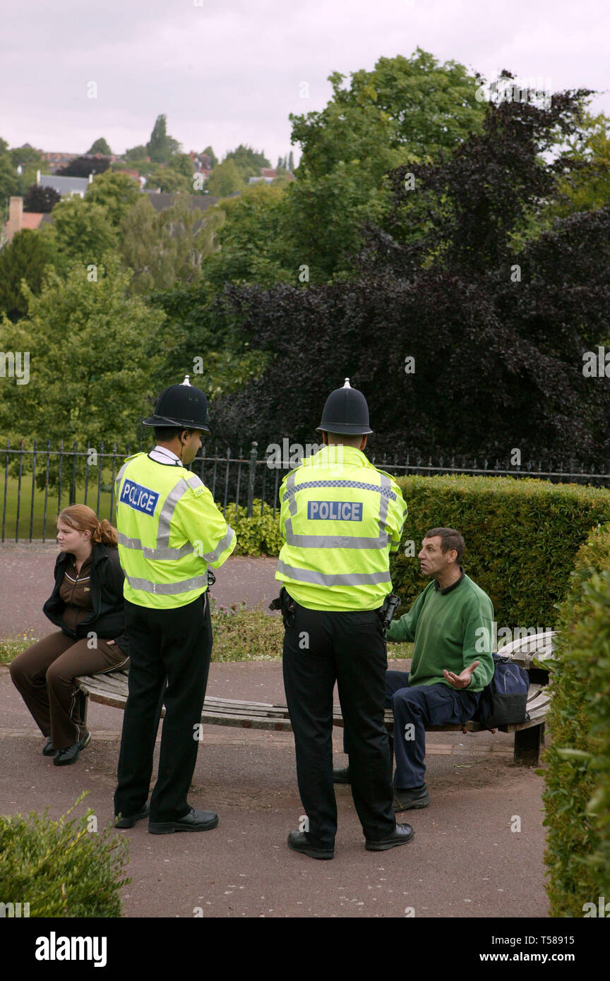 Policemen speaking to a man who has been drinking on a bench in a park. Nottingham. 16/07/2008 Stock Photo