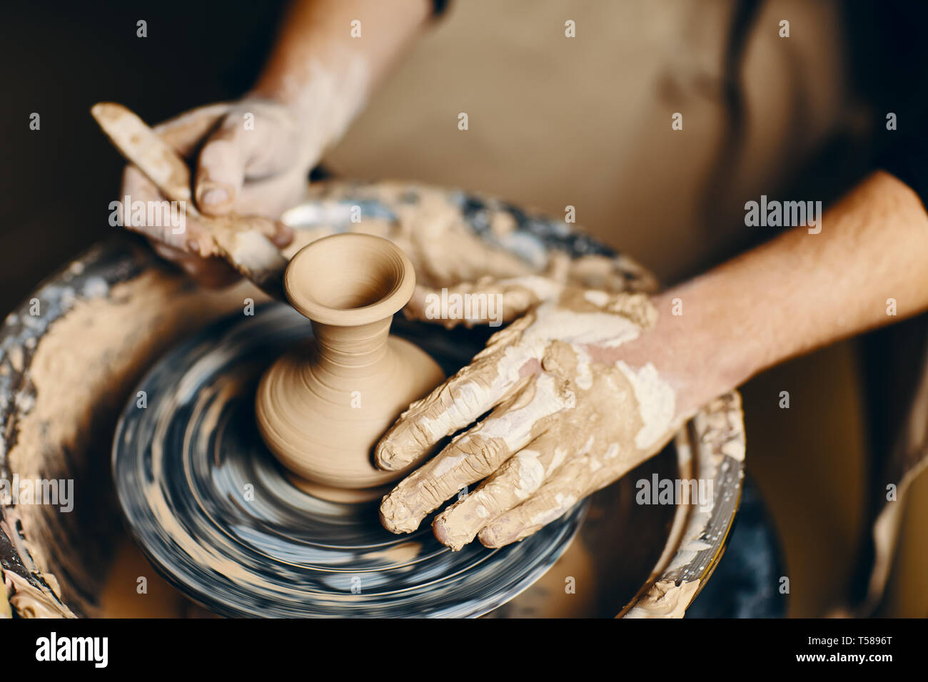 Modelling Pottery Potter modeling ceramic pot from clay on a potter's wheel. Workshop ...