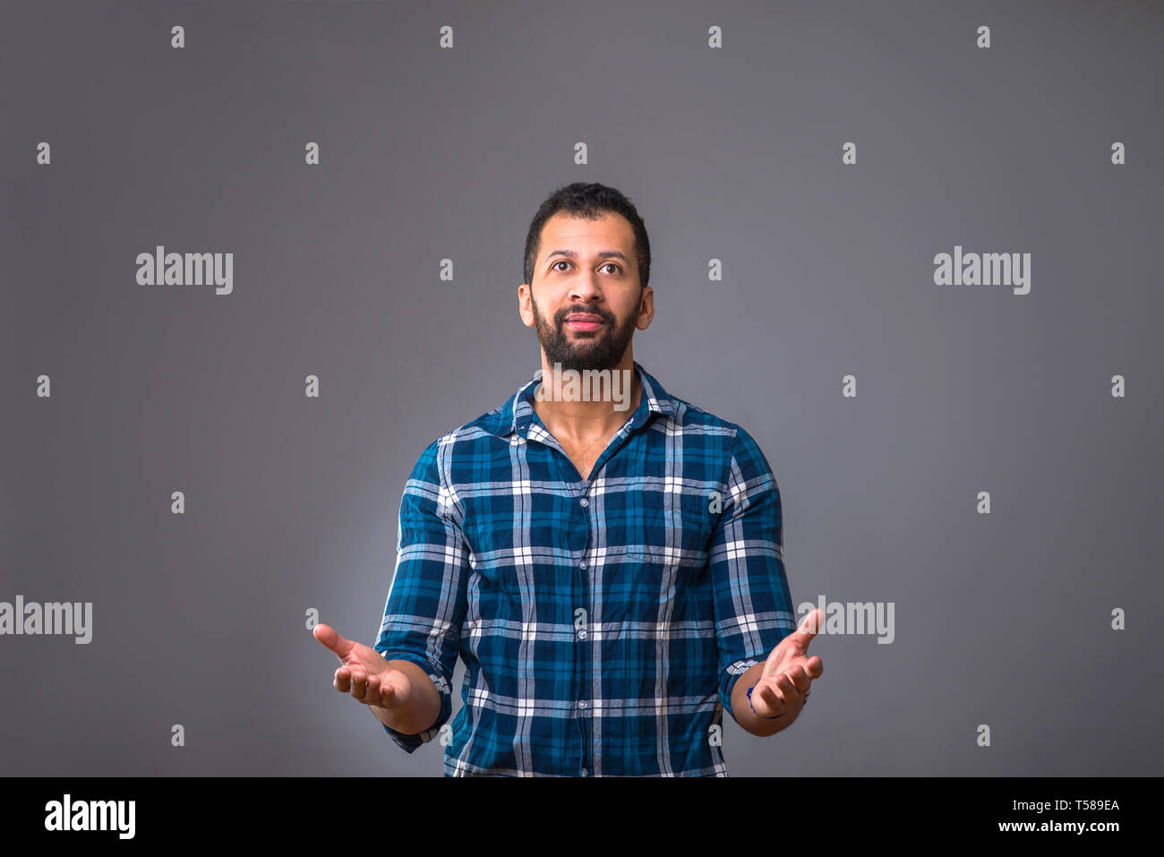 A young black man standing and feeling surprised Stock Photo