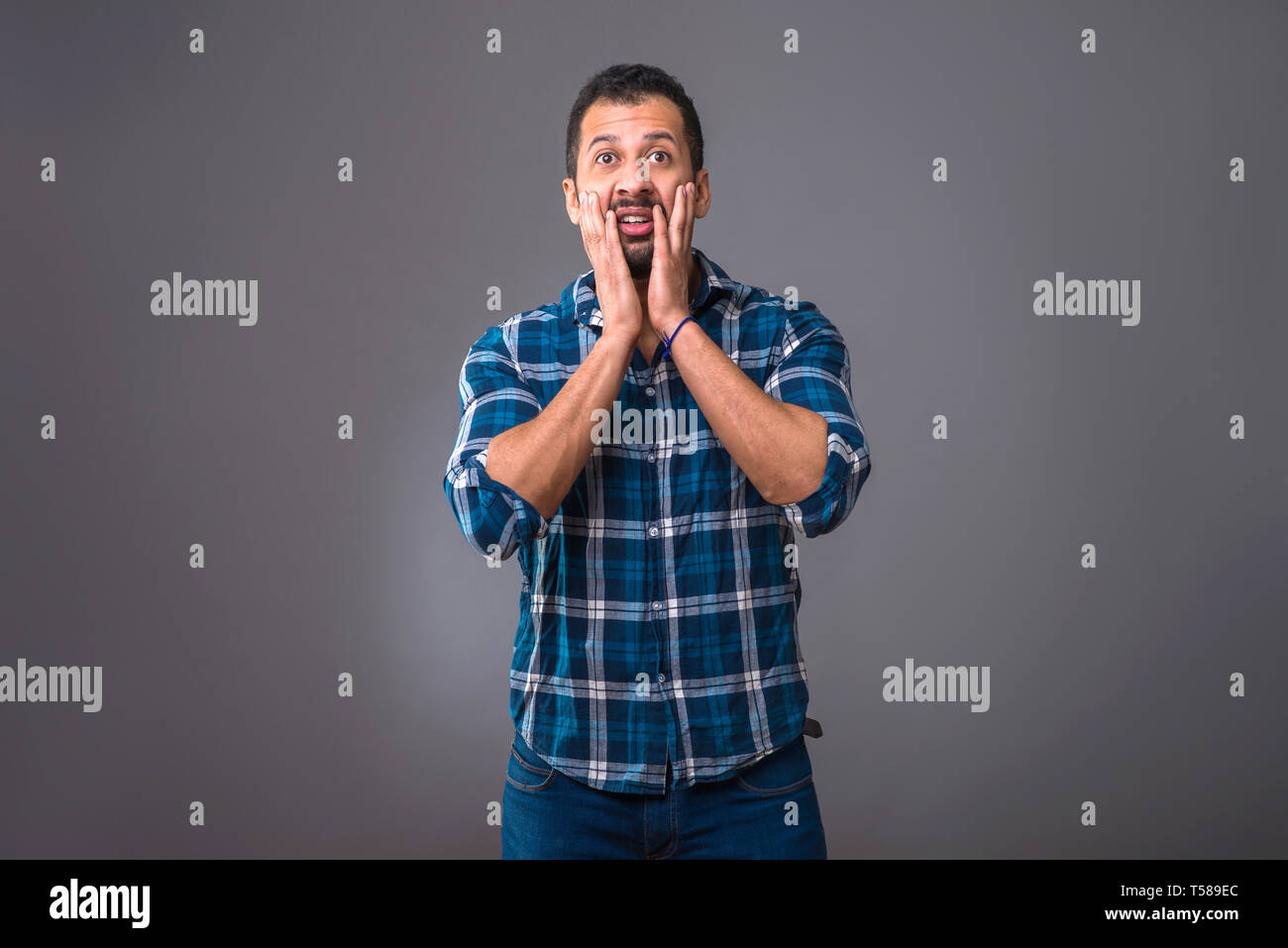 A young black man standing and feeling surprised Stock Photo