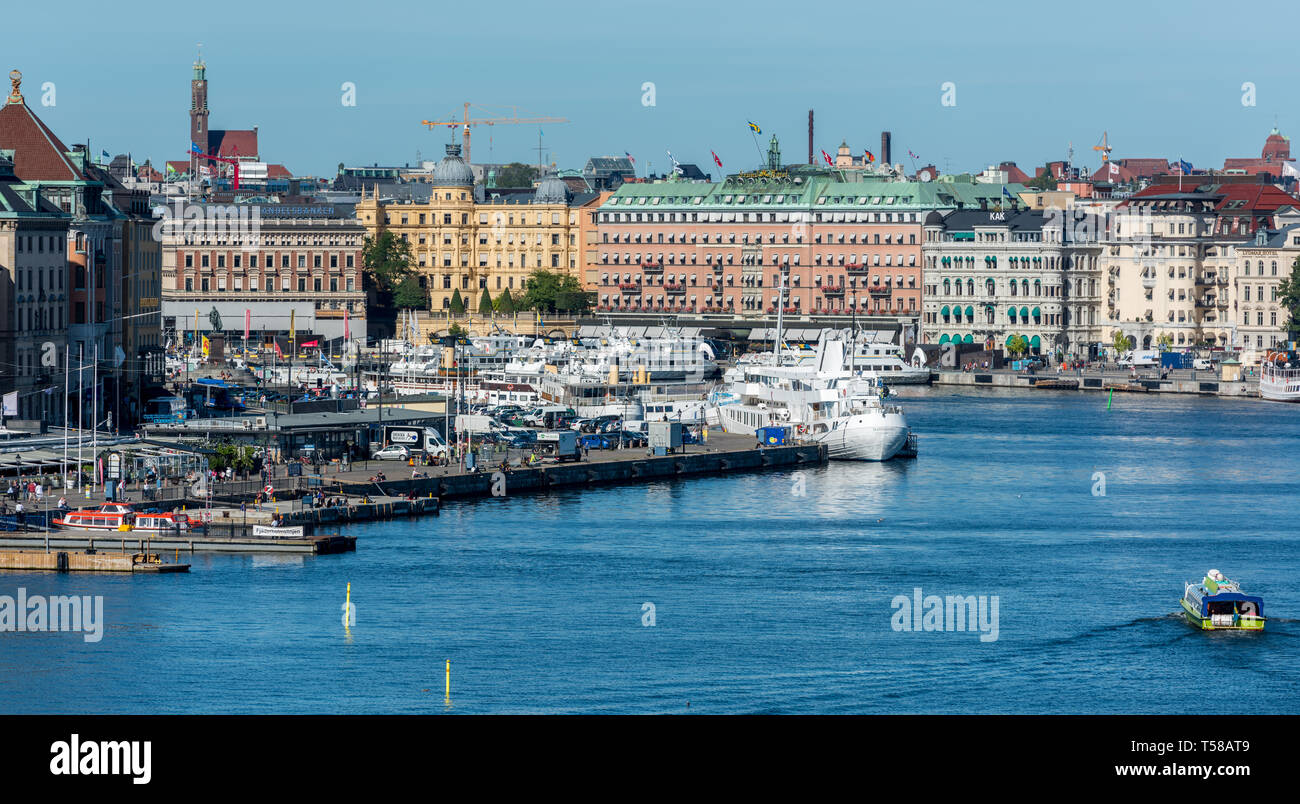 Ferries crowd the piers of Gamla stan overlooked by the grand buildings of Blasieholmen in the background Stock Photo