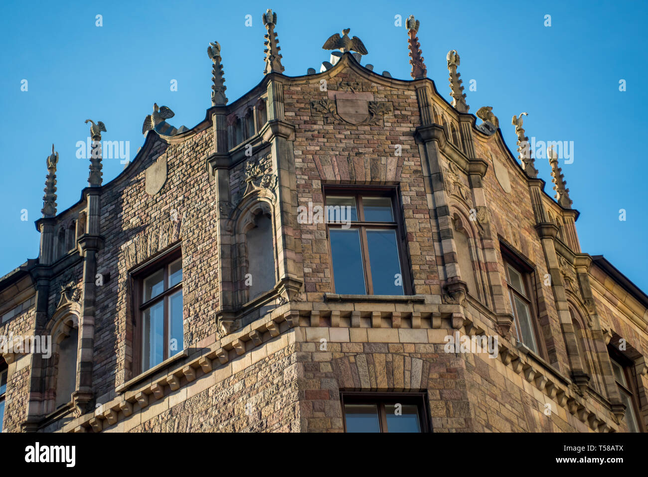 Stone birds sit atop an ornate mock gothic building in Bibliotekstan, the exclusive shopping district in Stockholm Stock Photo