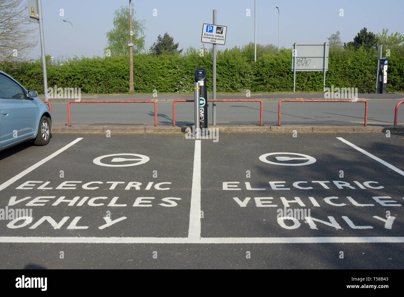 Electric vehicles only surface marking, two empty parking bays and electric vehicle recharging point and pole mounted sign in Bury Lancashire uk Stock Photo