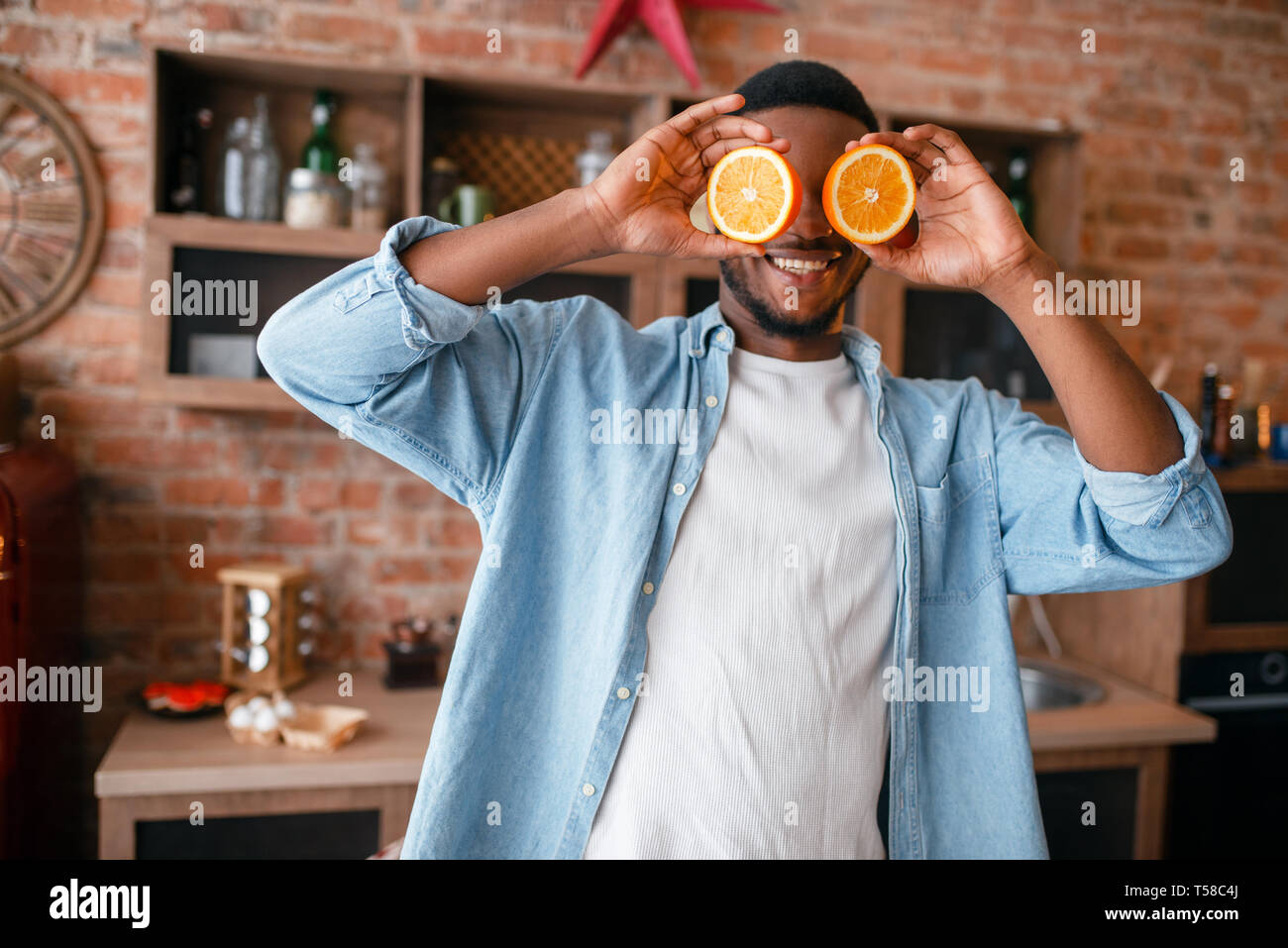 Black man having fun while cooking on the kitchen Stock Photo