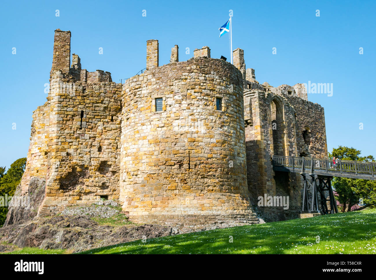 Medieval 13th century Dirleton Castle fortress with moat, popular visitor attraction, East Lothian, Scotland, UK with blue sky Stock Photo