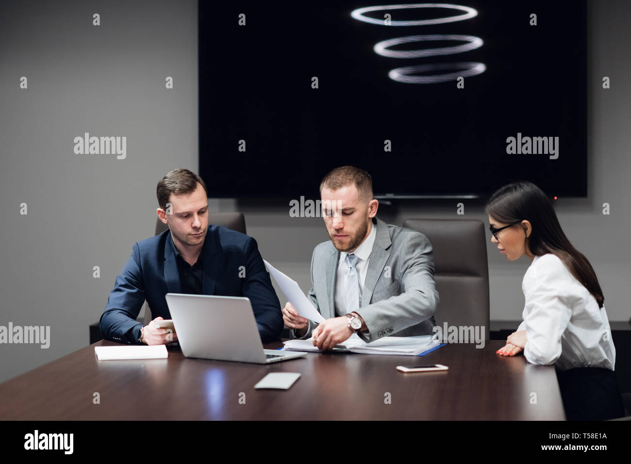 Business people working together on their laptop in a meeting room Stock Photo