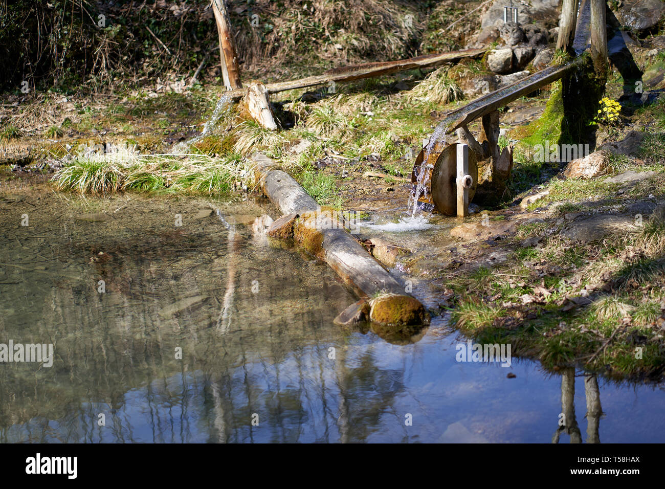 Small water whell with a pond in the forest Stock Photo