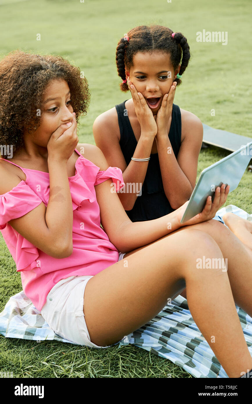 Surprised black girls watching video Stock Photo