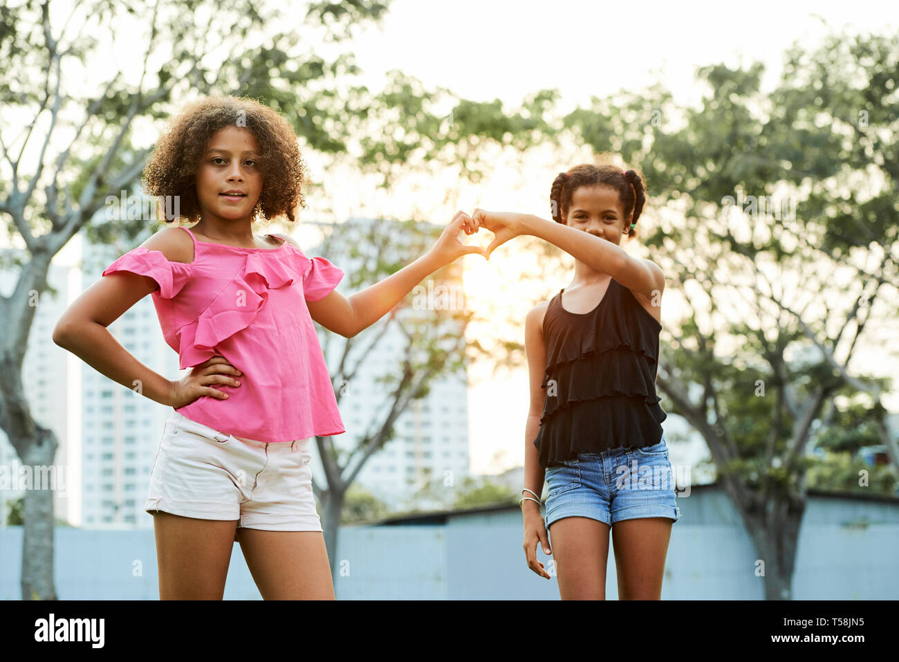Girls joining hands in shape of heart Stock Photo