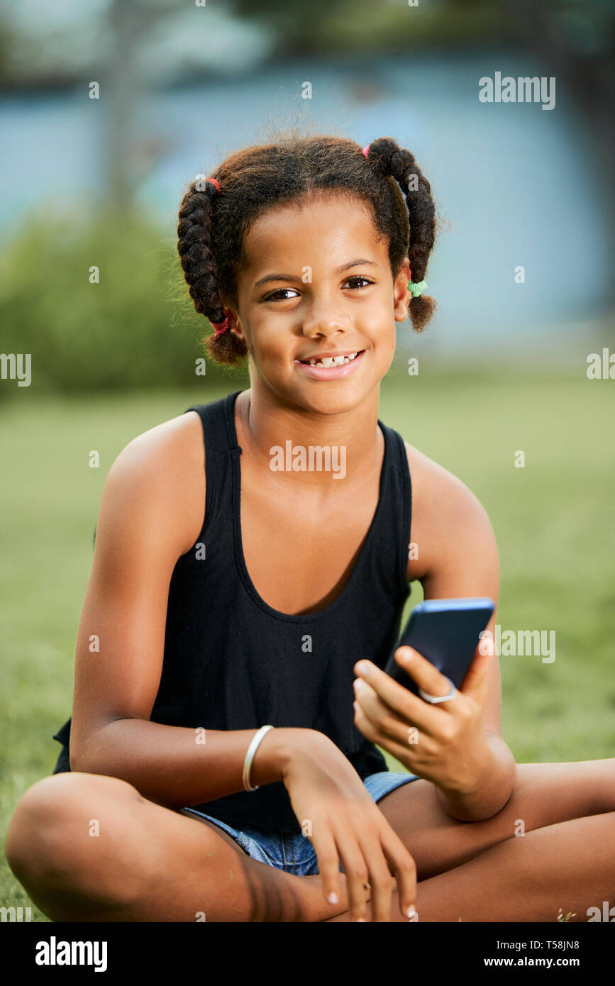 Black girl with funny braids using smartphone Stock Photo - Alamy
