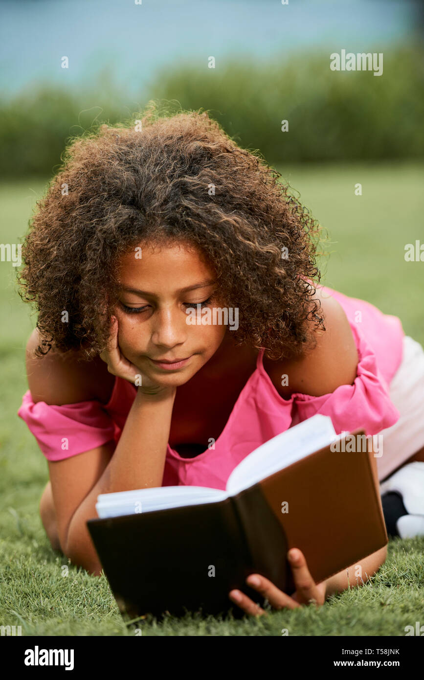 Curious girl reading literature Stock Photo