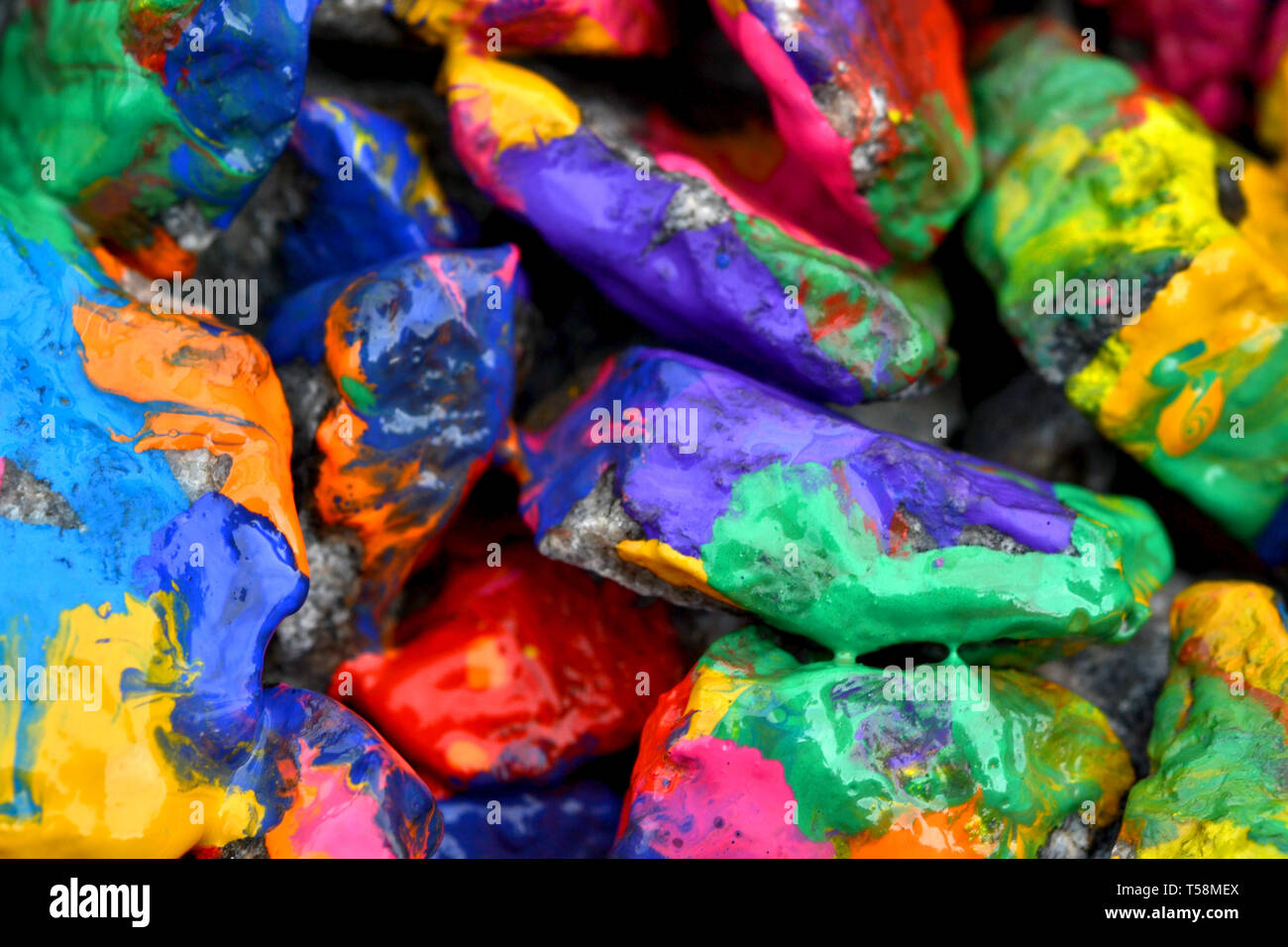 stones with colorful paint. Abstract background colored stones randomly in different colors Stock Photo