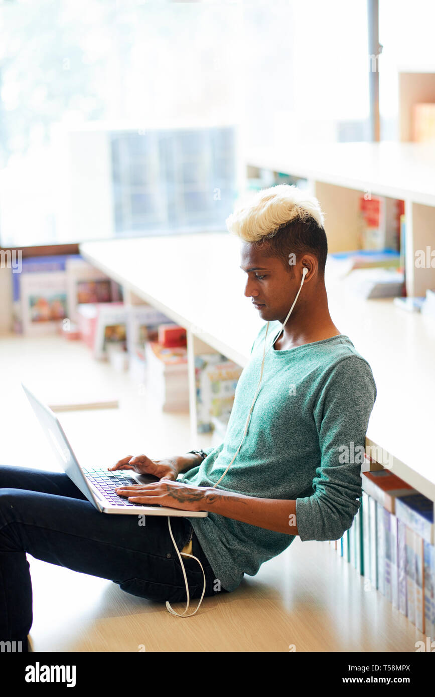 Hipster black student guy using laptop Stock Photo