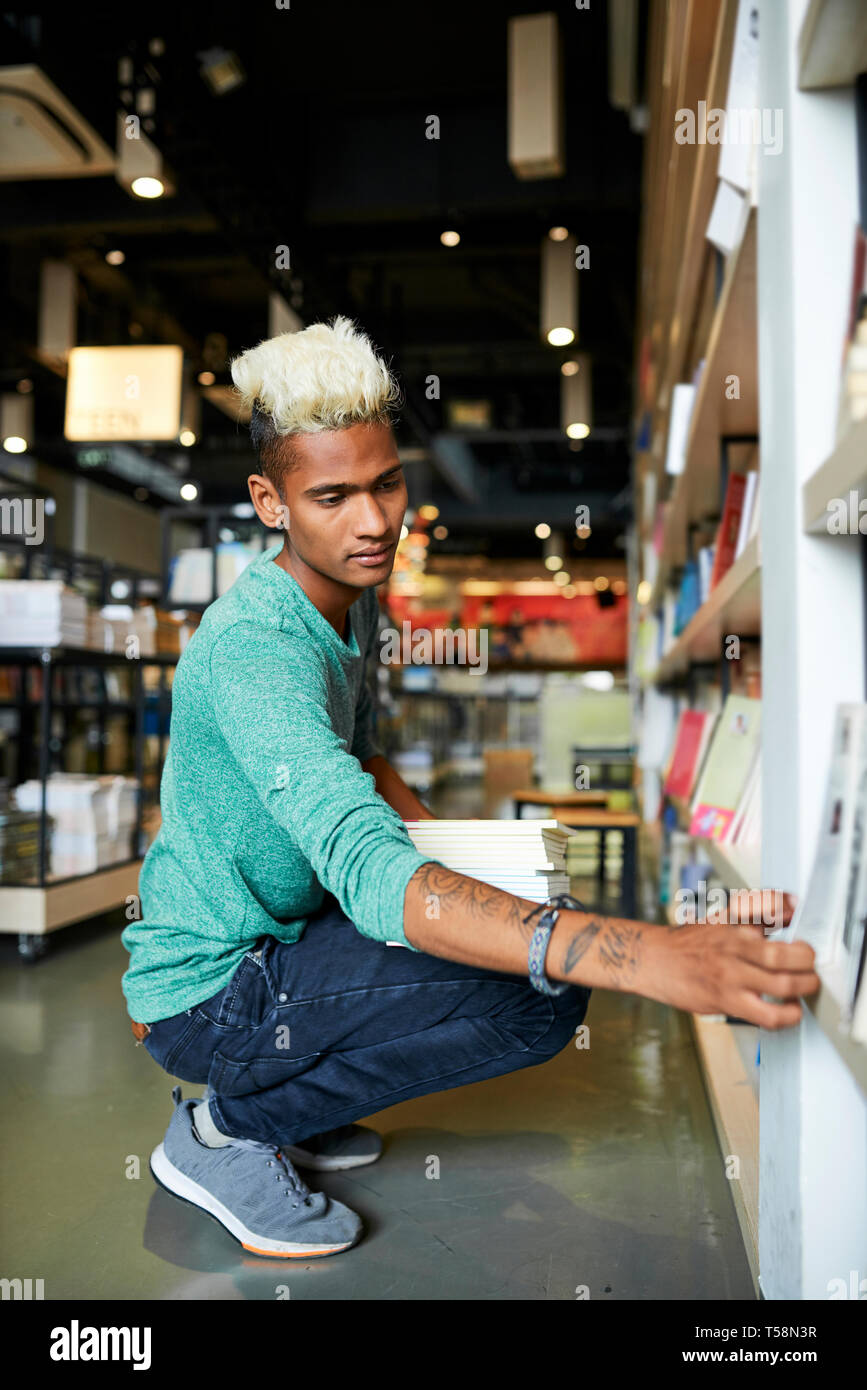 Young man working in bookstore Stock Photo