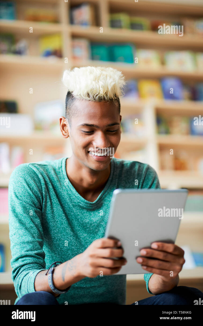 Cheerful black guy watching video on tablet Stock Photo