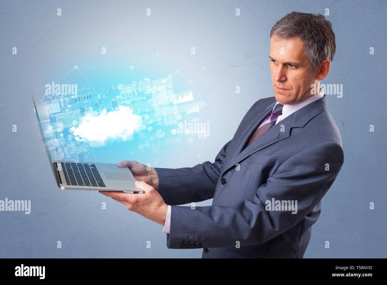 Man holding laptop projecting notifications, symbols and information based on cloud technology system  Stock Photo