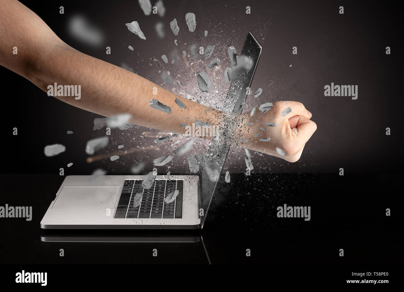 Strong male hand breaks laptop screen Stock Photo - Alamy