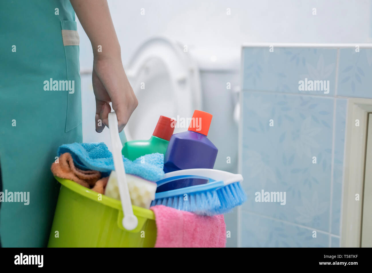 Aisian lady cleaning with a bucket and cleaning products on blurred ...