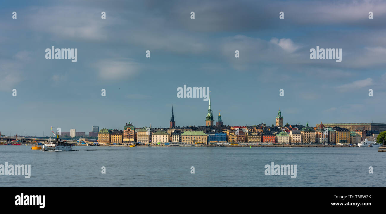 The towers of Riddarholm church, St Gertrud Tyska Kyrkan, City Hall and Storkyrkan rise above the colourful buildings of Gamla Stan lining the Baltic Stock Photo