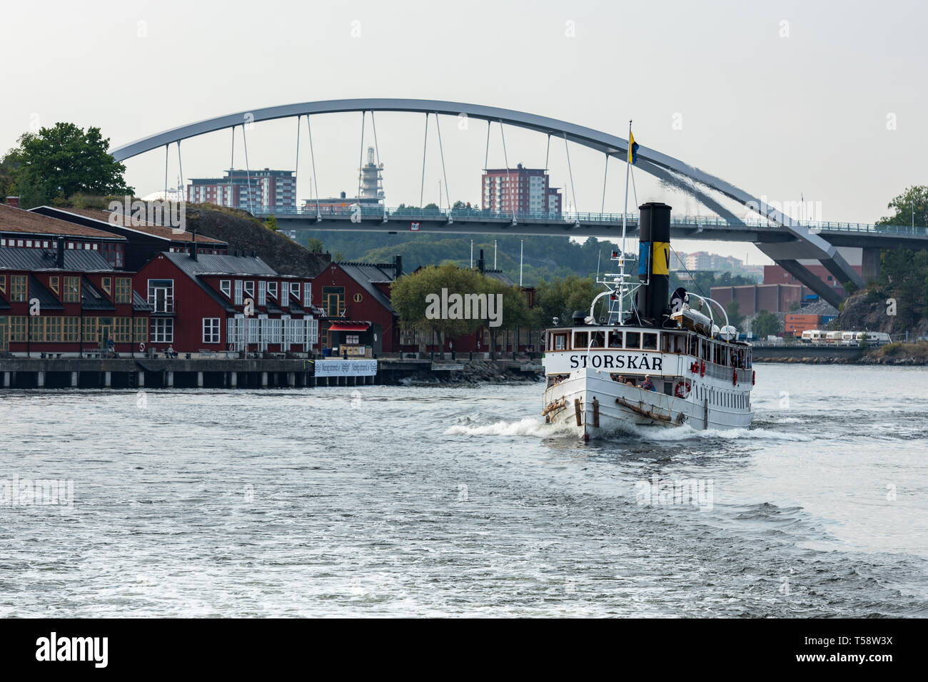 The historic SS Storskär passing Svindersviksbron and the Swedish Cruising Association (Svenska Kryssarklubben) in Nacka Strand, Stockholm Stock Photo